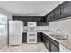 Kitchen with a white refrigerator, oven, and microwave, complemented by dark cabinetry and granite countertops at 8719 Lake Place Ln, Tampa, FL 33634