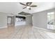 Spacious living room featuring a ceiling fan and natural light, seamlessly flowing into the adjacent kitchen and dining area at 8719 Lake Place Ln, Tampa, FL 33634