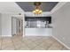 Open floorplan of the living room and kitchen with tile flooring, great natural light, and a ceiling fan at 8719 Lake Place Ln, Tampa, FL 33634