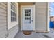Welcoming front door with a storm door and sidelight, enhanced by neutral siding and a tidy entrance area at 8719 Lake Place Ln, Tampa, FL 33634