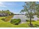 Picturesque lake view featuring lush green landscaping and a tranquil body of water under a bright sky at 8719 Lake Place Ln, Tampa, FL 33634
