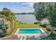 Community pool with lake view surrounded by lush landscaping and comfortable lounge chairs at 8719 Lake Place Ln, Tampa, FL 33634