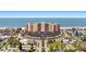 Aerial view of the oceanfront high rise with beachfront access and a roundabout parking area at 880 Mandalay Ave # C908, Clearwater Beach, FL 33767