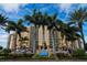 Stunning exterior of beachfront high rise building with palm trees and meticulously manicured landscaping at 880 Mandalay Ave # C908, Clearwater Beach, FL 33767