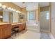 Luxurious bathroom featuring a double vanity, soaking tub, and glass-enclosed shower for a spa-like experience at 8933 Crescent Forest Blvd, New Port Richey, FL 34654