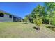 View of backyard and mature trees beyond the lawn with enclosure on home at 9211 Everwood Ct, Tampa, FL 33647