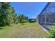 Private backyard with green lawn and screened enclosure, backs up to a wooded area and offers serene views at 9211 Everwood Ct, Tampa, FL 33647