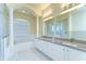 Luxurious primary bathroom featuring a soaking tub, walk-in shower, and double vanity with granite countertops at 9211 Everwood Ct, Tampa, FL 33647
