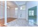 Bright foyer features a marble tile transitioning to wood flooring, a decorative front door, and a view of another room at 9211 Everwood Ct, Tampa, FL 33647