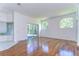 Living room with hardwood floors, arched windows, and sliding glass doors to the lanai at 9211 Everwood Ct, Tampa, FL 33647