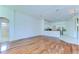 Bright living room with hardwood floors, partial kitchen view, and access to bathroom at 9211 Everwood Ct, Tampa, FL 33647
