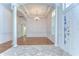 Room showcasing transition from marble tile to wood flooring, columns, and a chandelier at 9211 Everwood Ct, Tampa, FL 33647