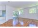 Bright living room with hardwood floors, arched windows, and access to outdoor space at 9211 Everwood Ct, Tampa, FL 33647