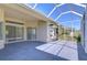 View of enclosed patio and backyard with sliding glass doors and large enclosure at 9211 Everwood Ct, Tampa, FL 33647