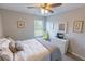 Bright bedroom featuring a ceiling fan, light gray walls, and a large window for natural light at 9660 Sweetwell Pl, Riverview, FL 33569