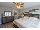 Comfortable bedroom with hardwood floors, ceiling fan, and adjacent bathroom at 9660 Sweetwell Pl, Riverview, FL 33569