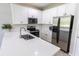 Modern kitchen with white cabinets, stainless steel appliances, and a spacious countertop at 9660 Sweetwell Pl, Riverview, FL 33569