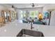 Open-concept living room features stylish furniture, a large window, and access to the patio at 9660 Sweetwell Pl, Riverview, FL 33569