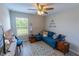 Cozy living room with a blue sectional sofa, a window, a ceiling fan, and a TV on a wooden dresser at 9660 Sweetwell Pl, Riverview, FL 33569