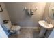 Convenient powder room features a pedestal sink, tiled floors, and neutral decor at 9660 Sweetwell Pl, Riverview, FL 33569