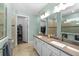 Elegant bathroom featuring double sinks, vanity, and a walk-in closet for ample storage at 9921 Pier Point Ter, Parrish, FL 34219