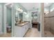 En-suite bathroom featuring double sinks, walk-in shower and views to bedroom at 9921 Pier Point Ter, Parrish, FL 34219