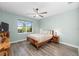 Bright bedroom features wood floors, ceiling fan, and window view of the pool area at 9921 Pier Point Ter, Parrish, FL 34219