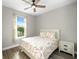 Cozy bedroom with hardwood floors, natural light from the window, and floral bedding at 9921 Pier Point Ter, Parrish, FL 34219