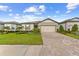 Charming single-story home with a well-manicured lawn, beautiful landscaping, and a brick paved driveway at 9921 Pier Point Ter, Parrish, FL 34219