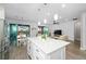 Open-concept kitchen with island, leading to a dining area and living room with backyard access at 9921 Pier Point Ter, Parrish, FL 34219