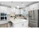Bright, modern kitchen with white cabinetry, a center island, stainless steel appliances, and pendant lighting at 9921 Pier Point Ter, Parrish, FL 34219