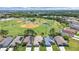 An aerial view of a residential neighborhood showcasing a home near a baseball field and lush greenery at 2452 Big Pine Dr, Holiday, FL 34691