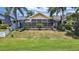 Large screened lanai overlooking a lush green lawn with mature palm trees at 2452 Big Pine Dr, Holiday, FL 34691