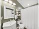 Well-lit bathroom featuring a white vanity, decorative mirror, and floral shower curtain at 2452 Big Pine Dr, Holiday, FL 34691