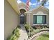 Inviting front door with an arched window detail, flanked by manicured landscaping and a green lawn at 2452 Big Pine Dr, Holiday, FL 34691