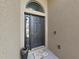 Close-up of the elegant black front door with sidelights, adorned with a decorative welcome mat at 2452 Big Pine Dr, Holiday, FL 34691