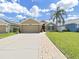 Charming single-story home with a well-manicured lawn, palm tree, and long driveway at 2452 Big Pine Dr, Holiday, FL 34691