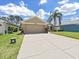 Charming home featuring an attached two-car garage and long driveway lined by a brick trim at 2452 Big Pine Dr, Holiday, FL 34691