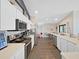 Bright eat-in kitchen with stainless steel appliances, white cabinets, and an open concept layout to adjacent living area at 2452 Big Pine Dr, Holiday, FL 34691
