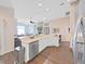 Open-concept kitchen with stainless steel appliances and view into living room with fireplace and built-in shelving at 2452 Big Pine Dr, Holiday, FL 34691