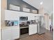 Modern kitchen featuring stainless steel appliances, white cabinetry, and designer backsplash at 2452 Big Pine Dr, Holiday, FL 34691