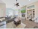 Inviting living room featuring a stone fireplace, built-in shelving, and an open layout at 2452 Big Pine Dr, Holiday, FL 34691