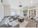 Spacious living room featuring a stone fireplace, ceiling fan, and a comfortable gray sectional sofa at 2452 Big Pine Dr, Holiday, FL 34691