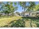 Expansive backyard featuring a covered carport and a lush lawn area, perfect for outdoor activities at 1025 W Berry Ave, Tampa, FL 33603