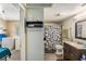 Bathroom with vanity, patterned shower curtain and view to a laundry area at 1025 W Berry Ave, Tampa, FL 33603