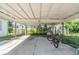 Large carport with mature landscaping, a barbeque, and room for parking at 1025 W Berry Ave, Tampa, FL 33603
