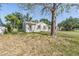 Charming single-story home featuring neutral trim and shuttered windows under mature shade trees at 1025 W Berry Ave, Tampa, FL 33603