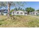 Charming single-story home with shuttered windows, and a well-maintained lawn under mature trees at 1025 W Berry Ave, Tampa, FL 33603