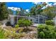 Backyard showcasing the pool enclosure, landscaping, fence, and the home's exterior at 10314 Lake Carroll Way, Tampa, FL 33618