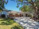 Single-story home featuring brick accents, a covered carport, and a beautifully landscaped front yard at 10314 Lake Carroll Way, Tampa, FL 33618